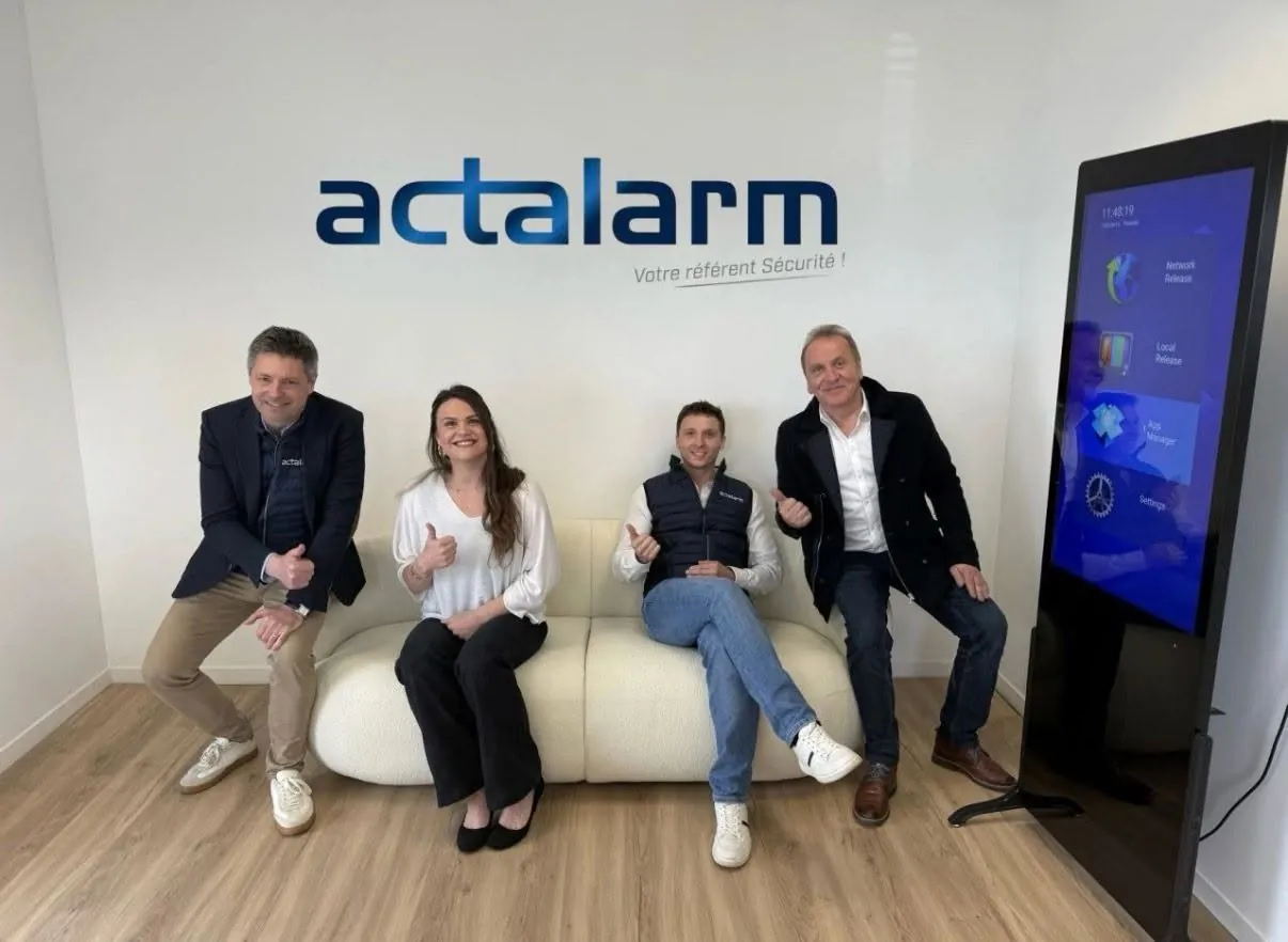 L’équipe Actalarm devant le logo de l’entreprise
